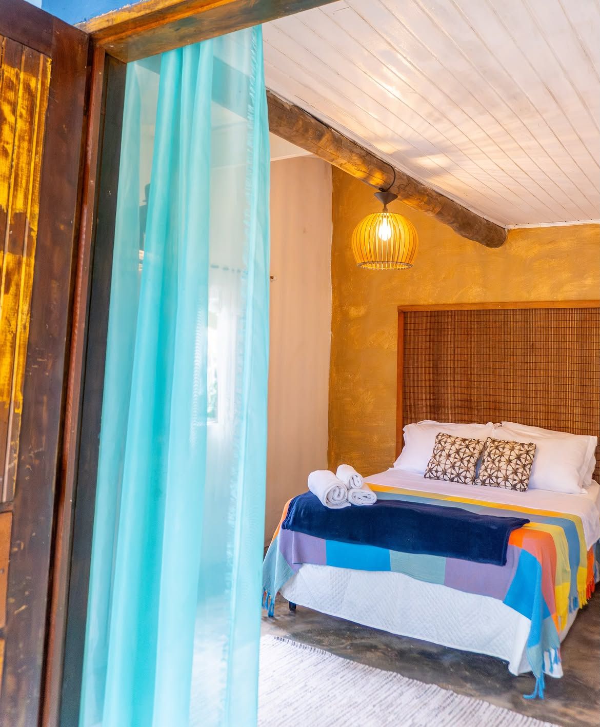 Quarto de casal visto pela cortina azul da porta