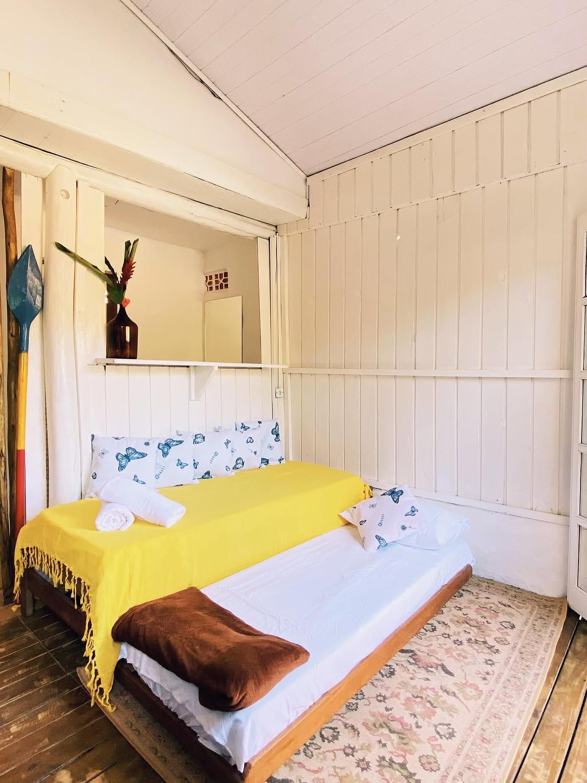 Quarto com cama de solteiro e colcha amarela